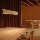 Singular Lighting - NINA Pendant P120-18 Rustic modern interior featuring a long natural wood LED pendant light above an oak dining table." (Otra opción para la segunda imagen, priorizando el estilo de decoración