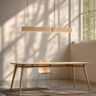 Singular Lighting - NINA Pendant P68+P120 4-5 02 Twin linear oak suspension luminaires casting warm light over a modern wooden desk in a bright room.