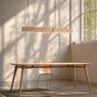 Singular Lighting - NINA Pendant P68+P120 4-5 02 Twin linear oak suspension luminaires casting warm light over a modern wooden desk in a bright room.