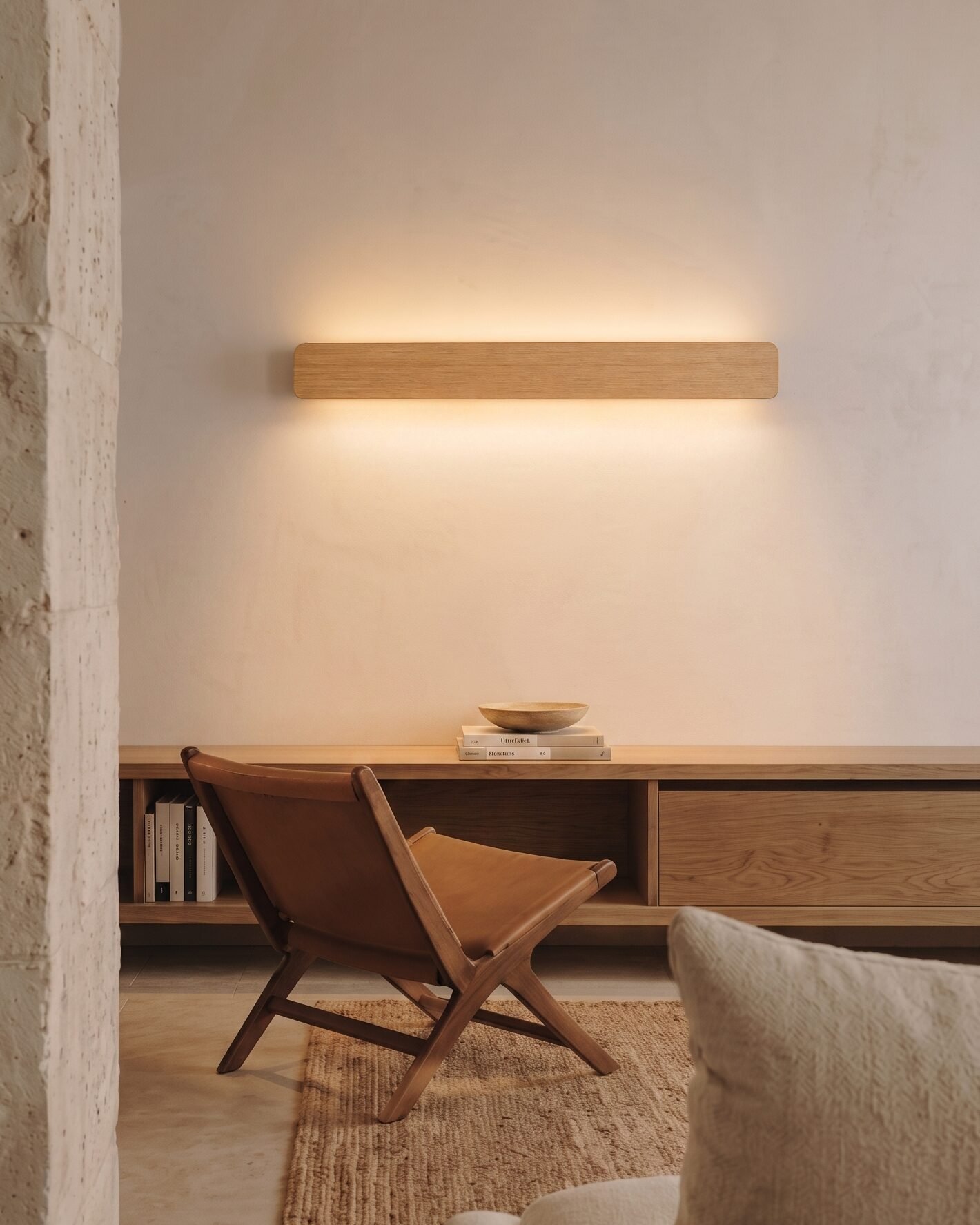 nina-wall-oak-linear-up-down-lighting-living-room Nina Wall linear wooden up-and-down lamp by Singular Lighting, in a minimal living room above an oak console with a leather chair. Warm ambient light, natural oak finish.