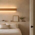 nina-wall-oak-linear-up-down-lighting-bedroom Bedroom view of the wooden Nina Wall linear lamp by Singular Lighting, mounted above a minimalist bed. Soft, natural lighting and simple decor.